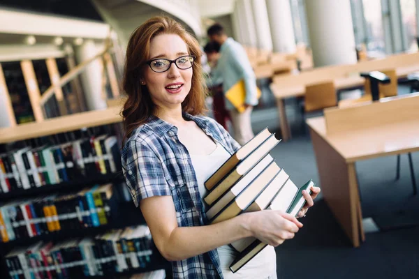 Junge Studentin in der Bibliothek — Stockfoto