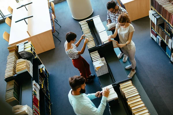 Estudiantes atractivos pasar tiempo en la biblioteca — Foto de Stock