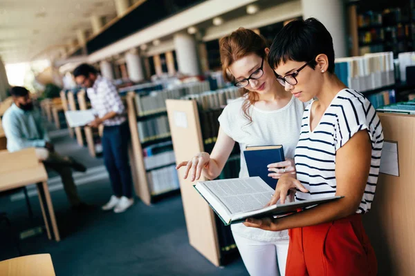 Estudiantes atractivos pasar tiempo en la biblioteca — Foto de Stock