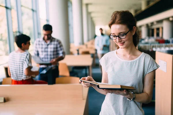 Ung kvinnlig student i biblioteket — Stockfoto