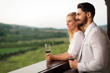 İnsanlar üzüm bağında şarap tadıyor.