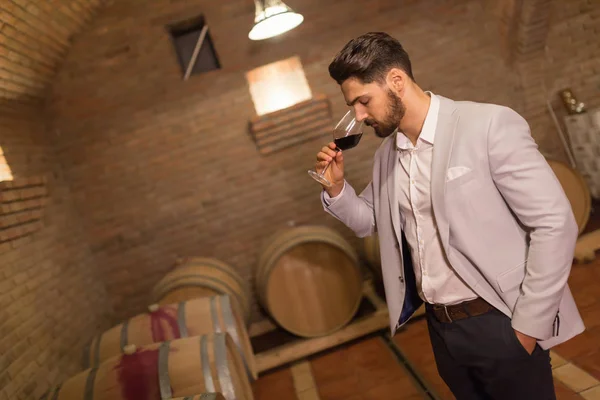 Oenologist tasting wines in cellar