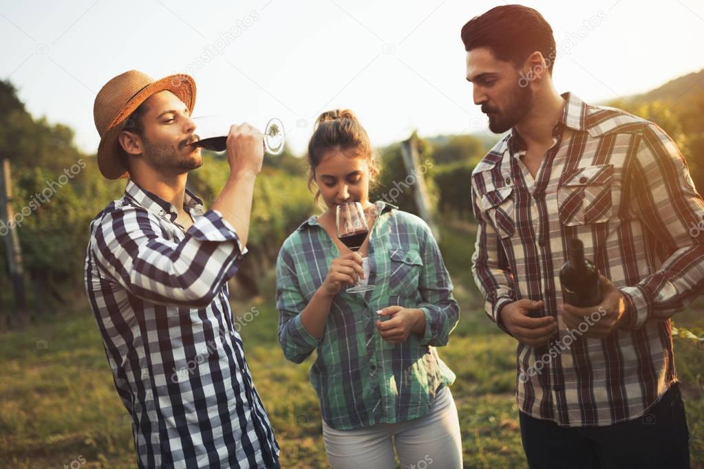 Wine tourists tasting wine in vineyard