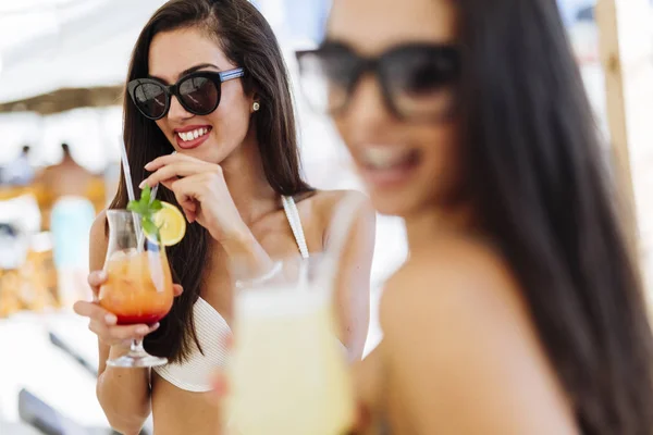 Vrouwen op het strand genieten van cocktails — Stockfoto