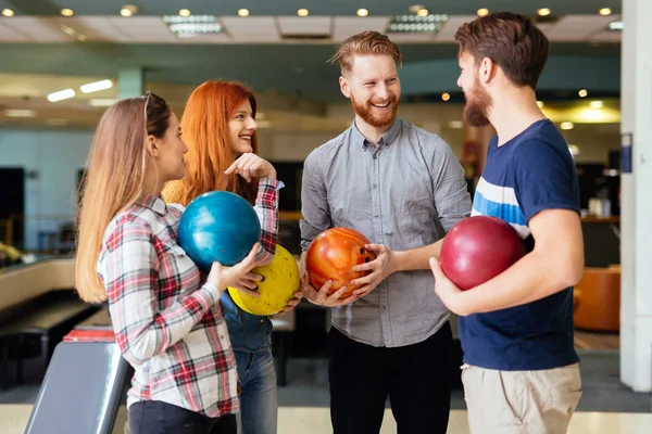 Cheerful friends bowling together