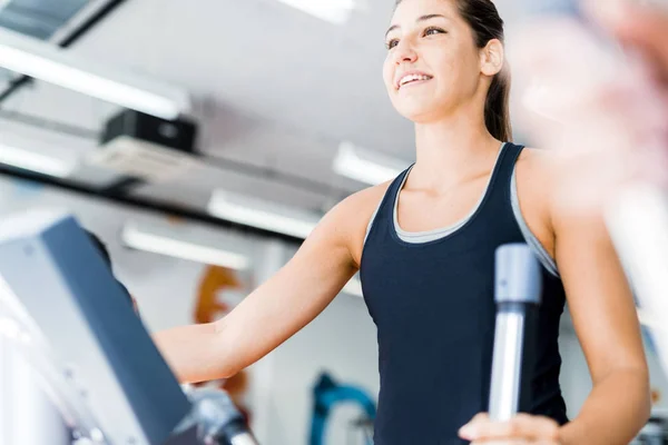 Señorita usando el entrenador elíptico — Foto de Stock