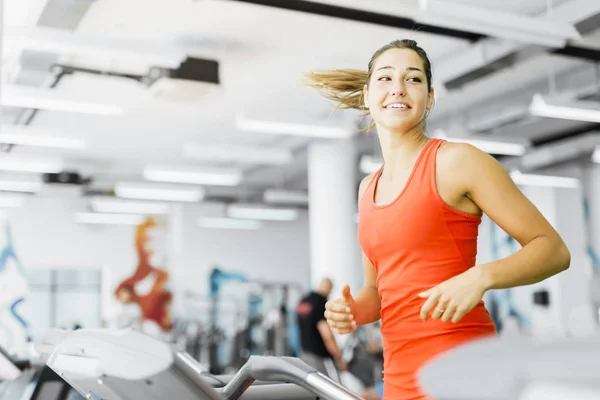 Kobieta, bieganie na bieżni w siłowni — Zdjęcie stockowe