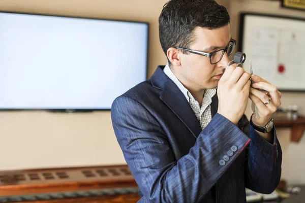 Jeweler examining diamond through loupe — Stock Photo, Image