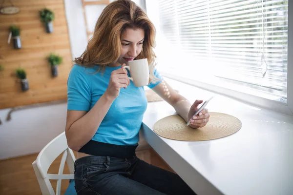 Kvinna dricka kaffe och läsa nyheter — Stockfoto