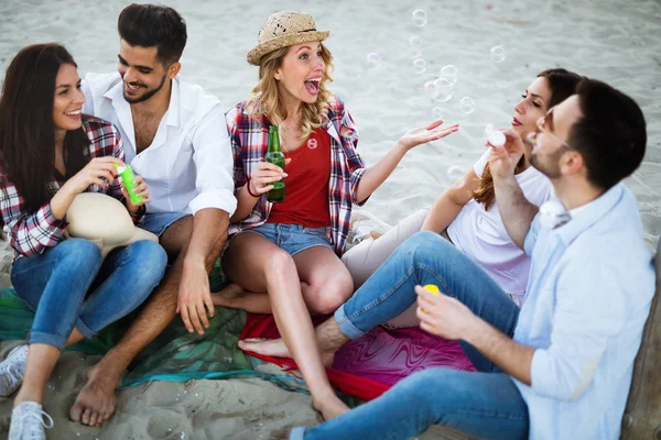 Glada människor dricka och ha roligt på stranden — Stockfoto