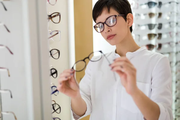 Mulher está escolhendo novos óculos — Fotografia de Stock
