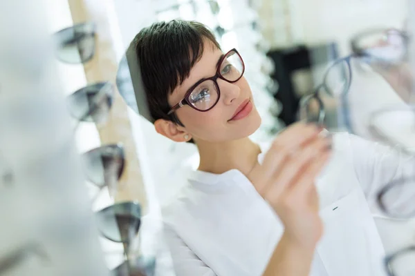 Mujer está eligiendo nuevas gafas — Foto de Stock