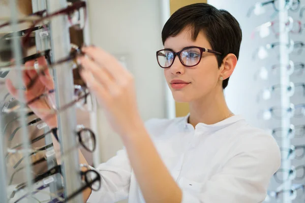 Mujer está eligiendo nuevas gafas — Foto de Stock