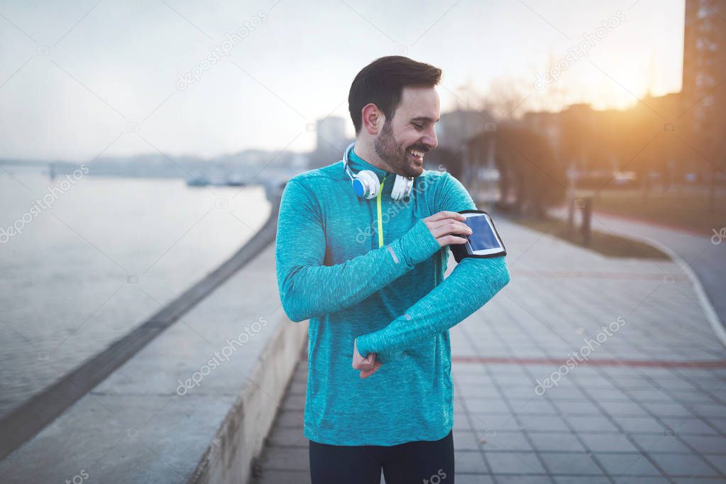 Handsome jogger listening to music
