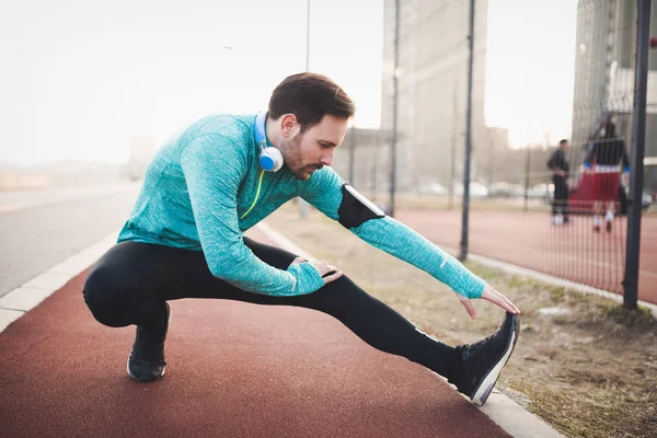 Hombre estiramiento antes de hacer ejercicio — Foto de Stock