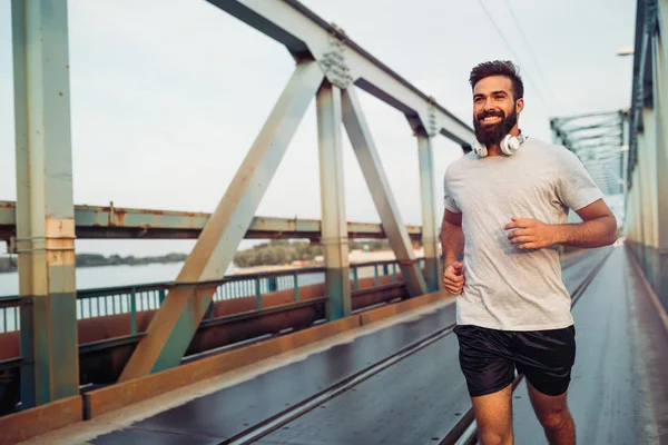 Hombre feliz corriendo a través del puente — Foto de Stock