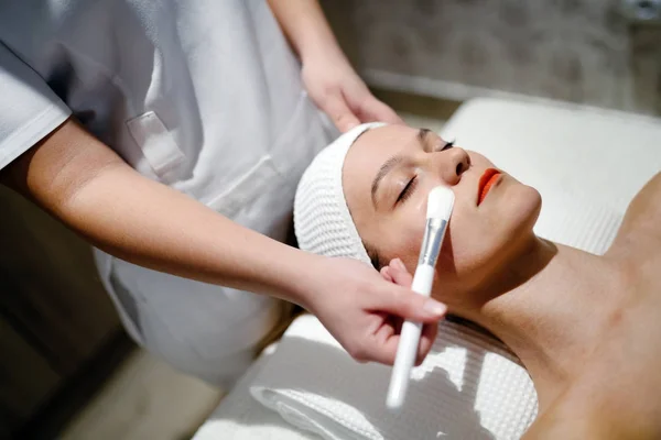 Masseur aplicando máscara facial — Fotografia de Stock