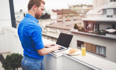 Çatı katında dizüstü bilgisayar kullanan iş kişi