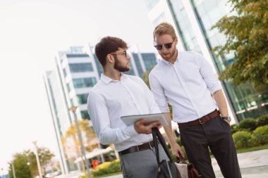 İş adamları dışarıda konuşuyor.