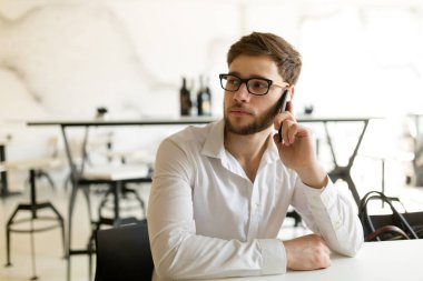 Telefonunuzun ve kafede dalgın genç işadamı