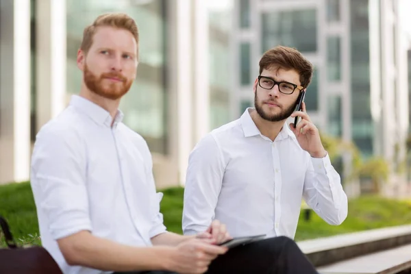 Business colleagues sitting on bench — Stock Photo, Image