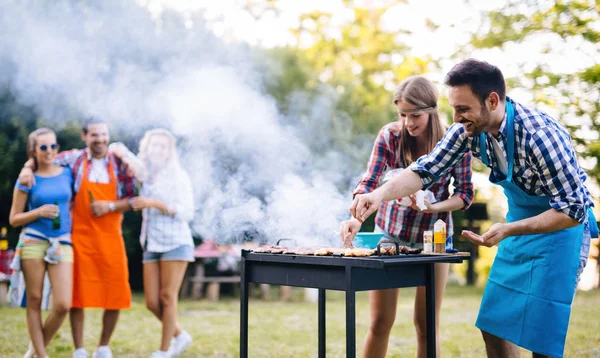 Lykkelige venner som nyter grillfest – stockfoto