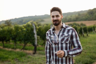 Şarap üreticisi Üzüm bağında şarap tadıyor