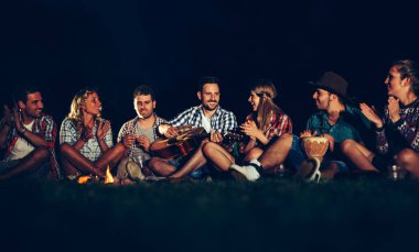 Arkadaşlar kamp ateşi yakın müzik keyfi