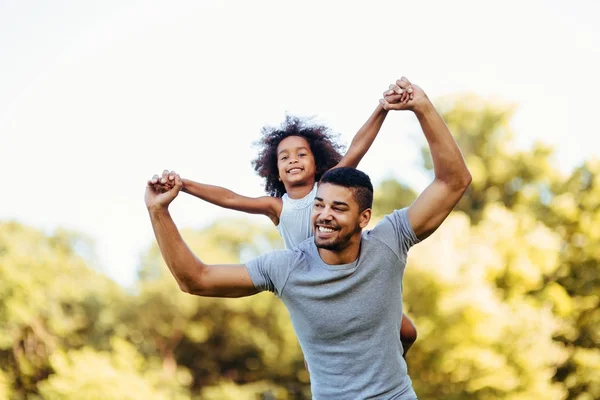 Padre cargando a su hija en su espalda — Foto de Stock