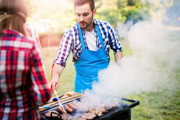 Lykkelige venner som nyter grillfest – stockfoto