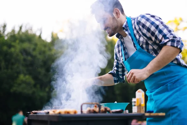 Handsome happy male preparing barbecue — Stock Photo, Image