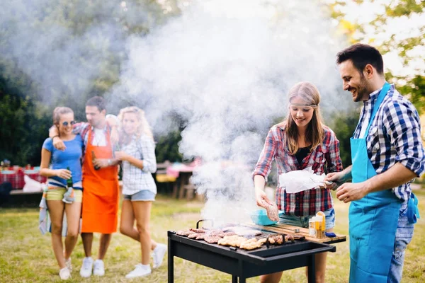 Lykkelige venner som nyter grillfest – stockfoto