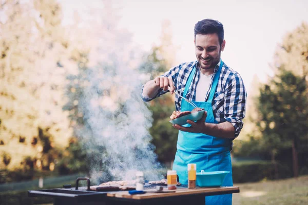 Bonito homem preparando churrasco — Fotografia de Stock