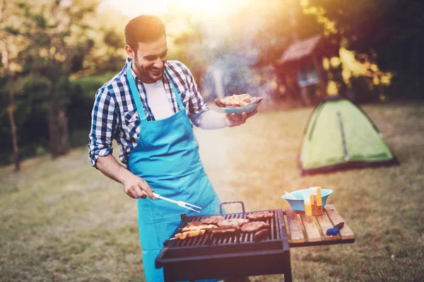 Handsome happy male preparing barbecue — Stock Photo, Image