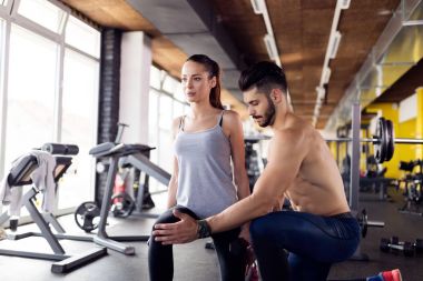 Akciğer egzersiz eğitmen ile spor salonunda genç çekici kadın