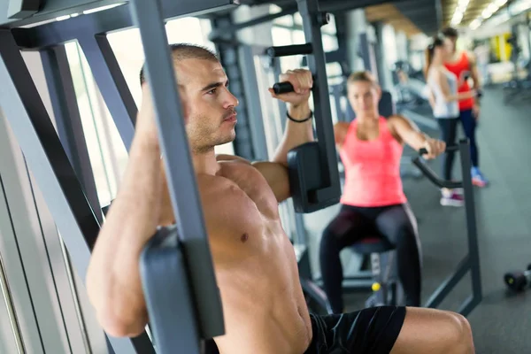 有魅力的男人和美丽的女人在健身房做胸部锻炼锻炼 — 图库照片