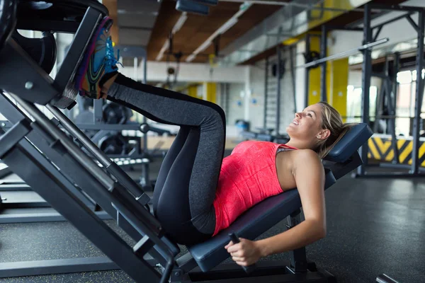女人做压腿机上健身房运动 — 图库照片