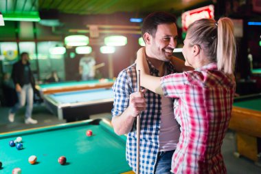 Genç çift birlikte havuz çalmaya