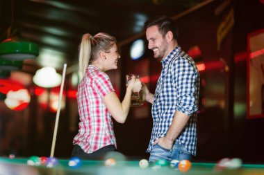 Genç çift birlikte havuz çalmaya