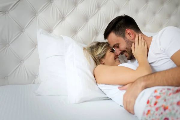 Man och kvinna kysser på säng — Stockfoto