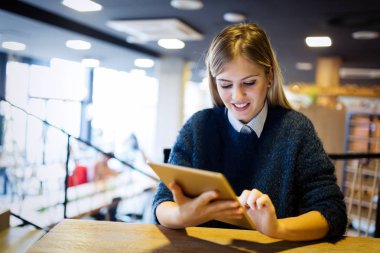  Tablet kahve dükkanında kullanan kadın