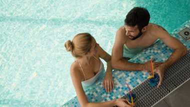Yüzme havuzunda dinlenen bir çift.