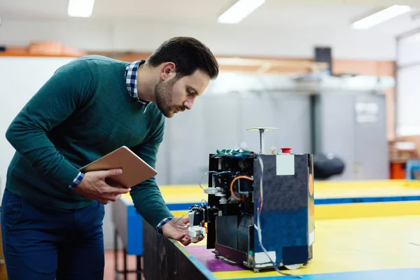 Junger Ingenieur testet seinen Roboter — Stockfoto