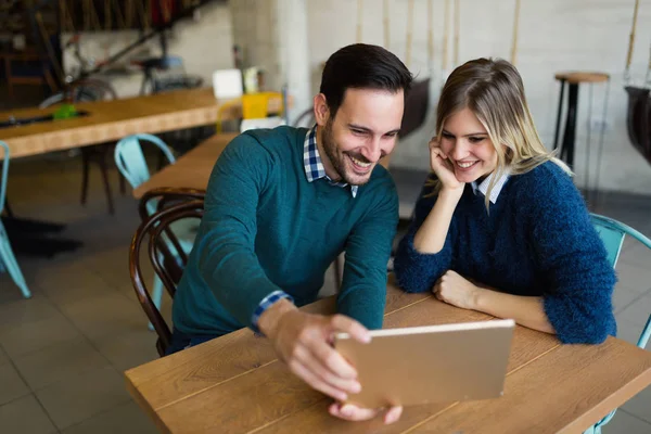 Hombre y mujer en la fecha mirando en la tableta — Foto de Stock