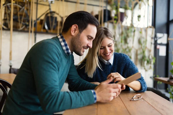 Hombre y mujer en la fecha mirando en la tableta —  Fotos de Stock