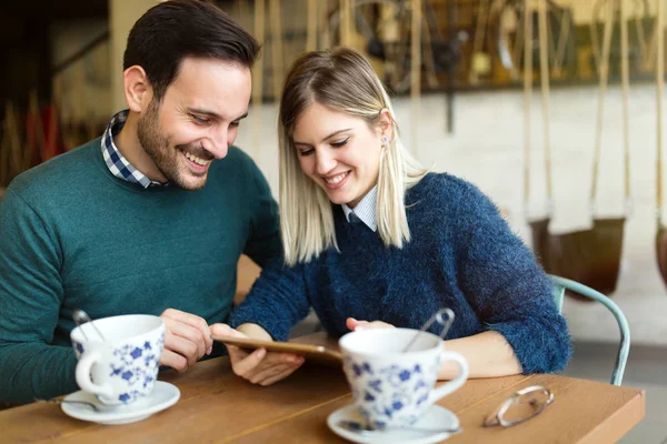 Hombre y mujer en la fecha mirando en la tableta — Foto de Stock