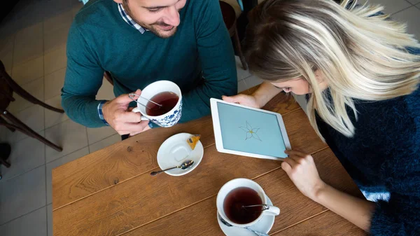 Mann und Frau beim Date auf Tablet schauen — Stockfoto