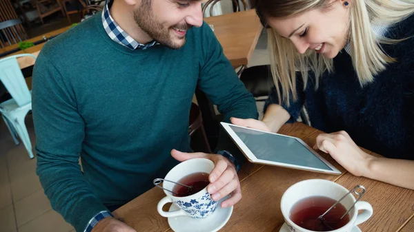 Man and  woman on date looking on tablet — Stock Photo, Image