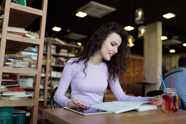 Junge Frau liest Buch im Café — Stockfoto