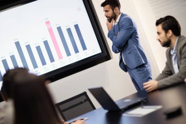 Konferans salonu birinde için sunuyu gösteren genç çekici işadamı